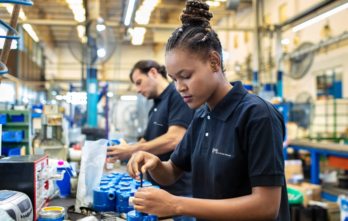 Workers assembling a machine part