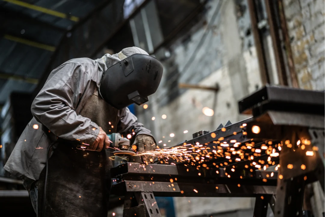 A staff member grinding a metal part